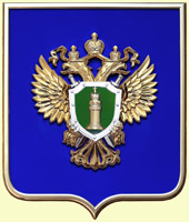 Герб Прокуратуры РФ на геральдическом щите в раме на синем бархате. Покрытие эмблемы - металлизация.